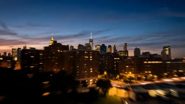 Frame from the AI video result for the prompt: Day turns to night over the city as the lights come on